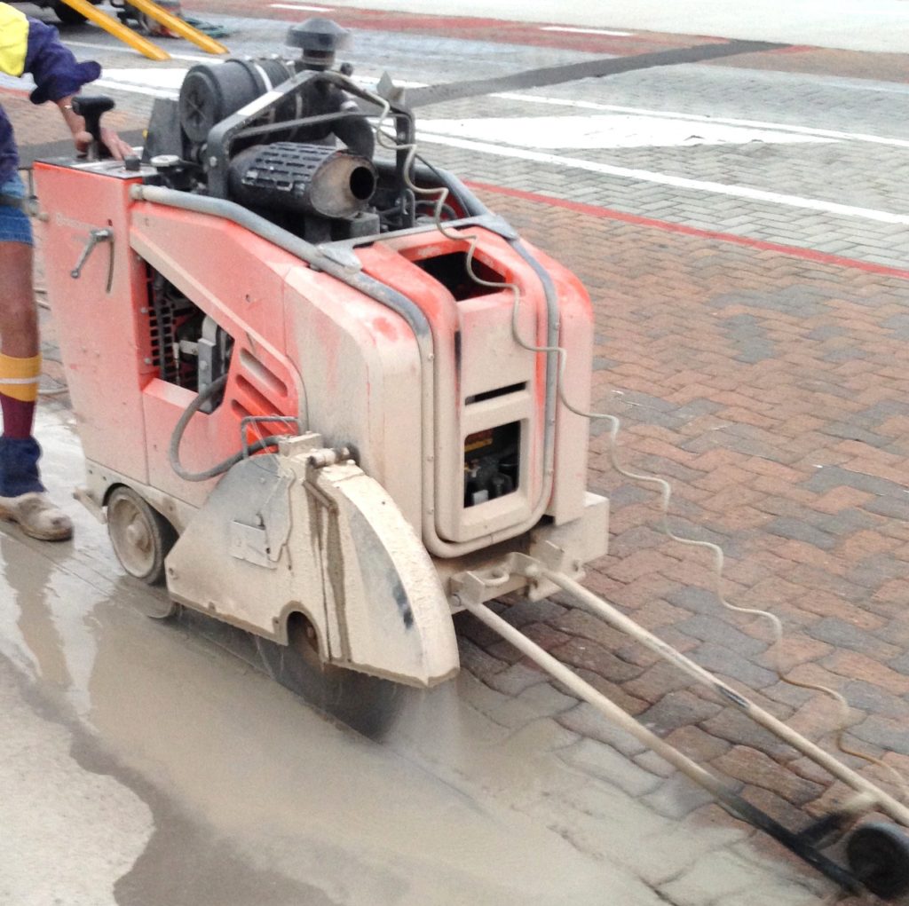 Cutting concrete edge in prep for replacing pavers